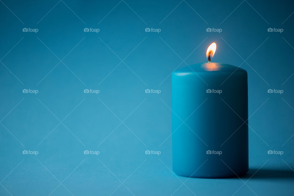 Blue candle isolated on blue background