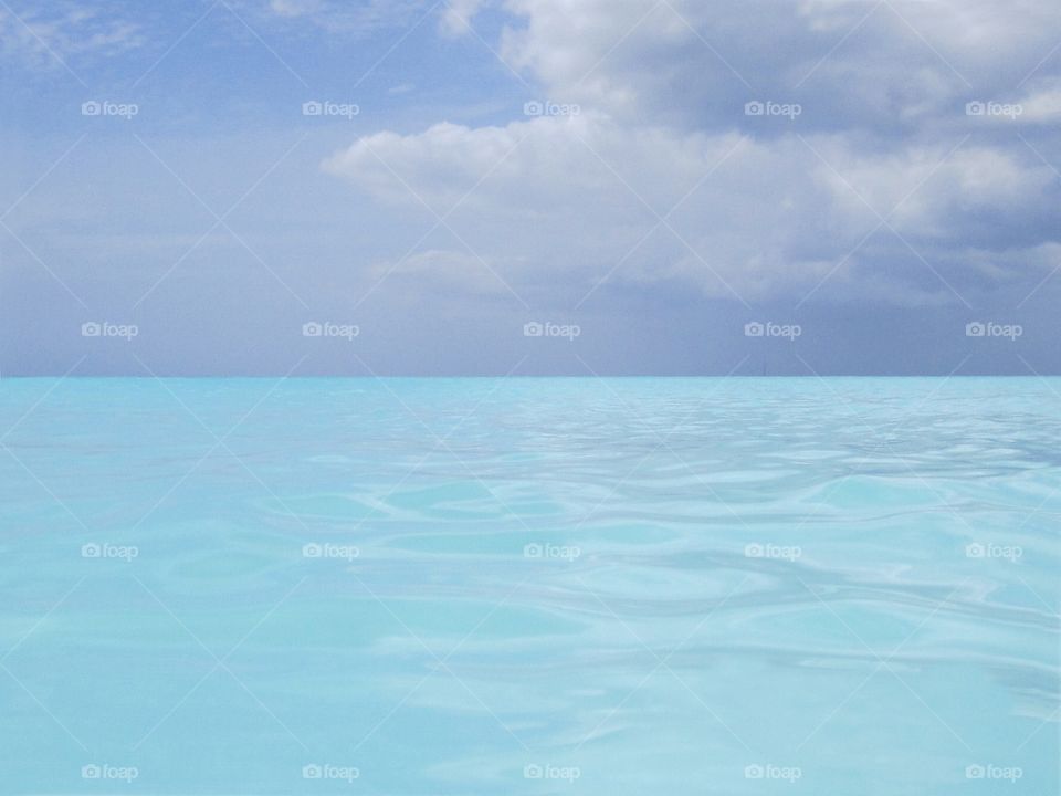 Beautiful neon baby blue carribean waters off the coast of Antigua beach.