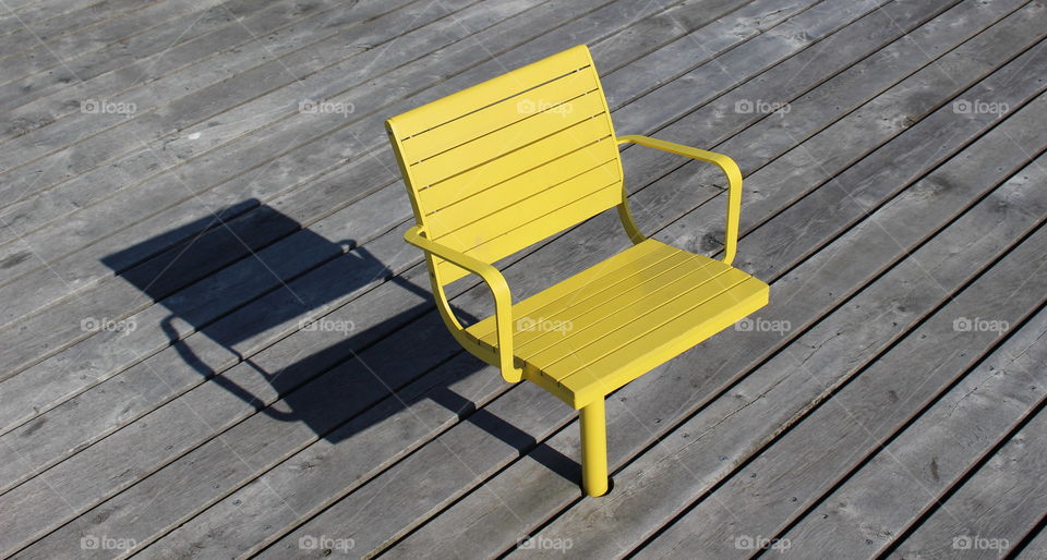 Yellow chair on wooden boardwalk