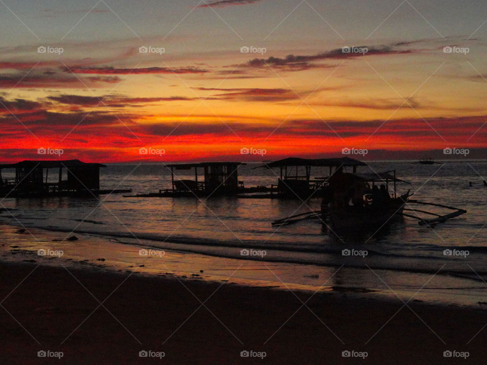 Scenic view of beach against sky at sunset 