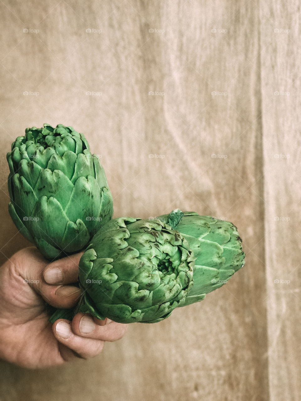 Hand holding artichokes 