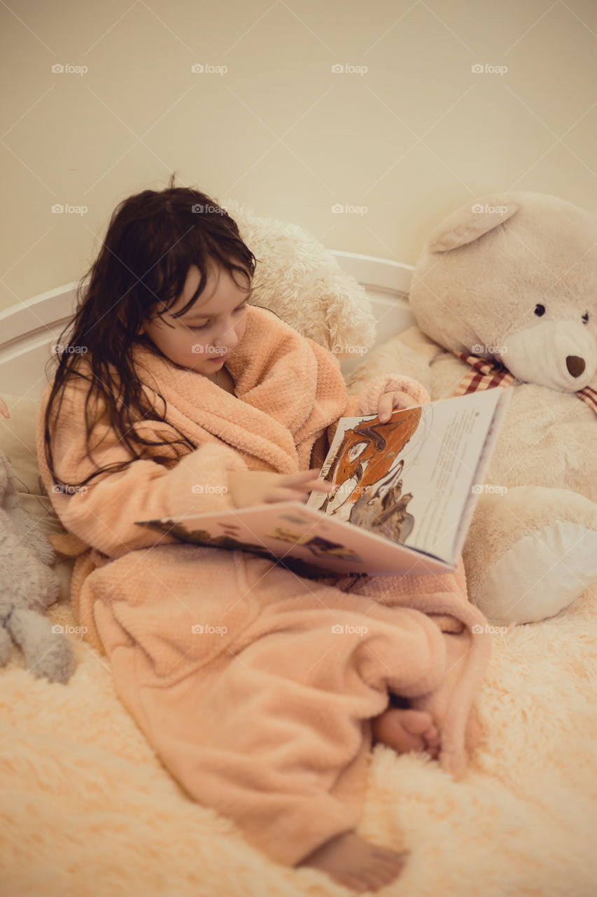 Girl in bathrobe reading the book