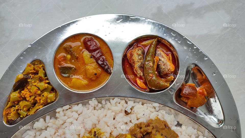 Rice with Sambar and fish curry, spicy curry from India,  Indian vegetarian and non-vegetarian curry, food from India, Thoran(left end) and lemon pickle (right end) and a lot more