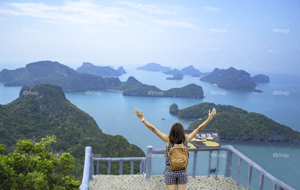 Women raise their arms and shoulder backpack on Pha Jun Jaras Viewpoint at Angthong Islands , Suratthani in Thailand