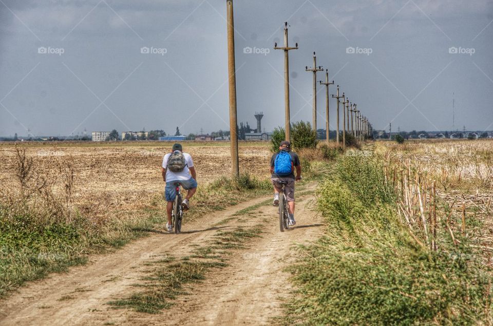 Cyclists in the country with light poles on the way