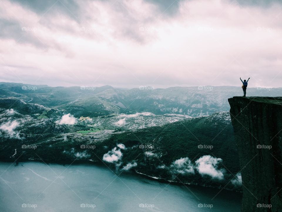 Person standing on top of a cliff