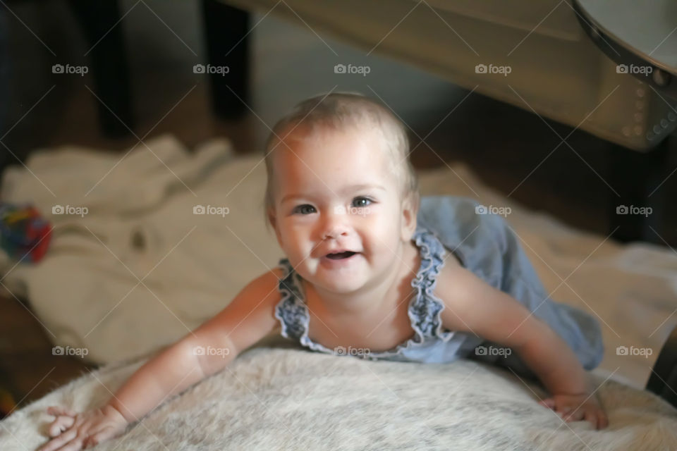 Baby laying down and smiling.