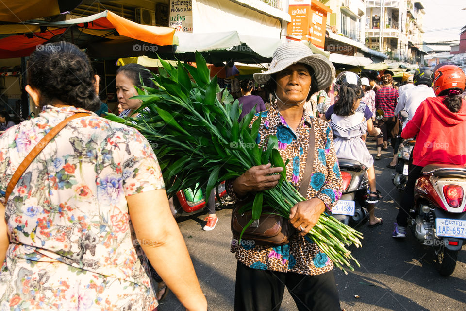Asian woman seller green leaves at the market