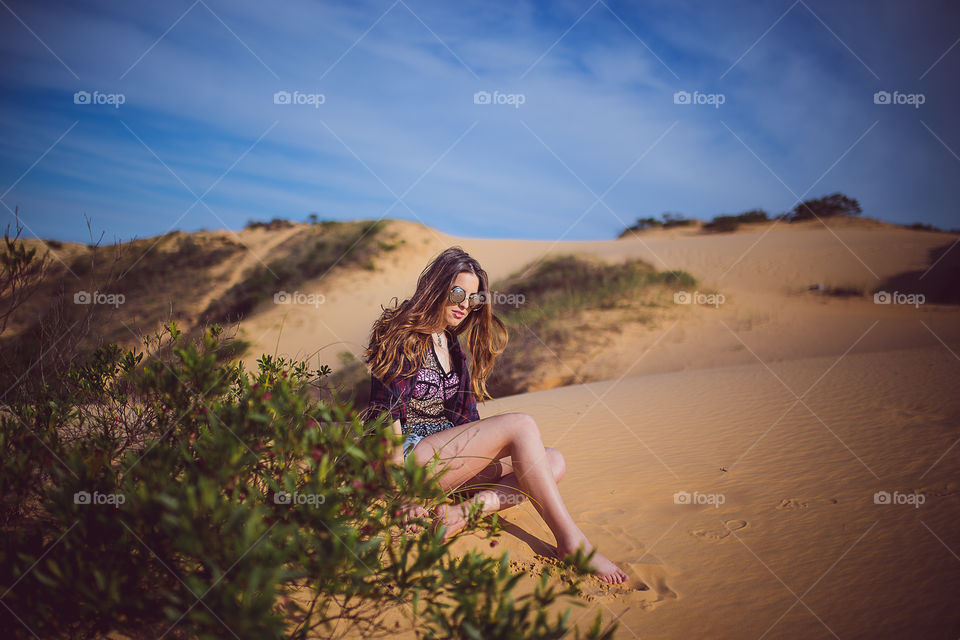 Woman sitting on sand