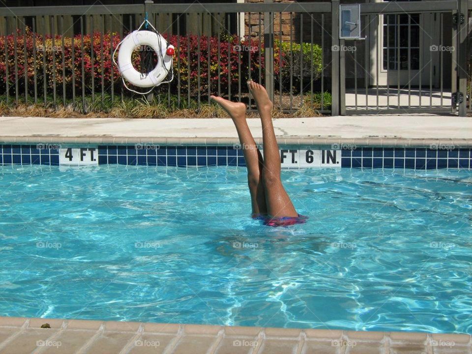 Child in swimming upside down with legs sticking straight up