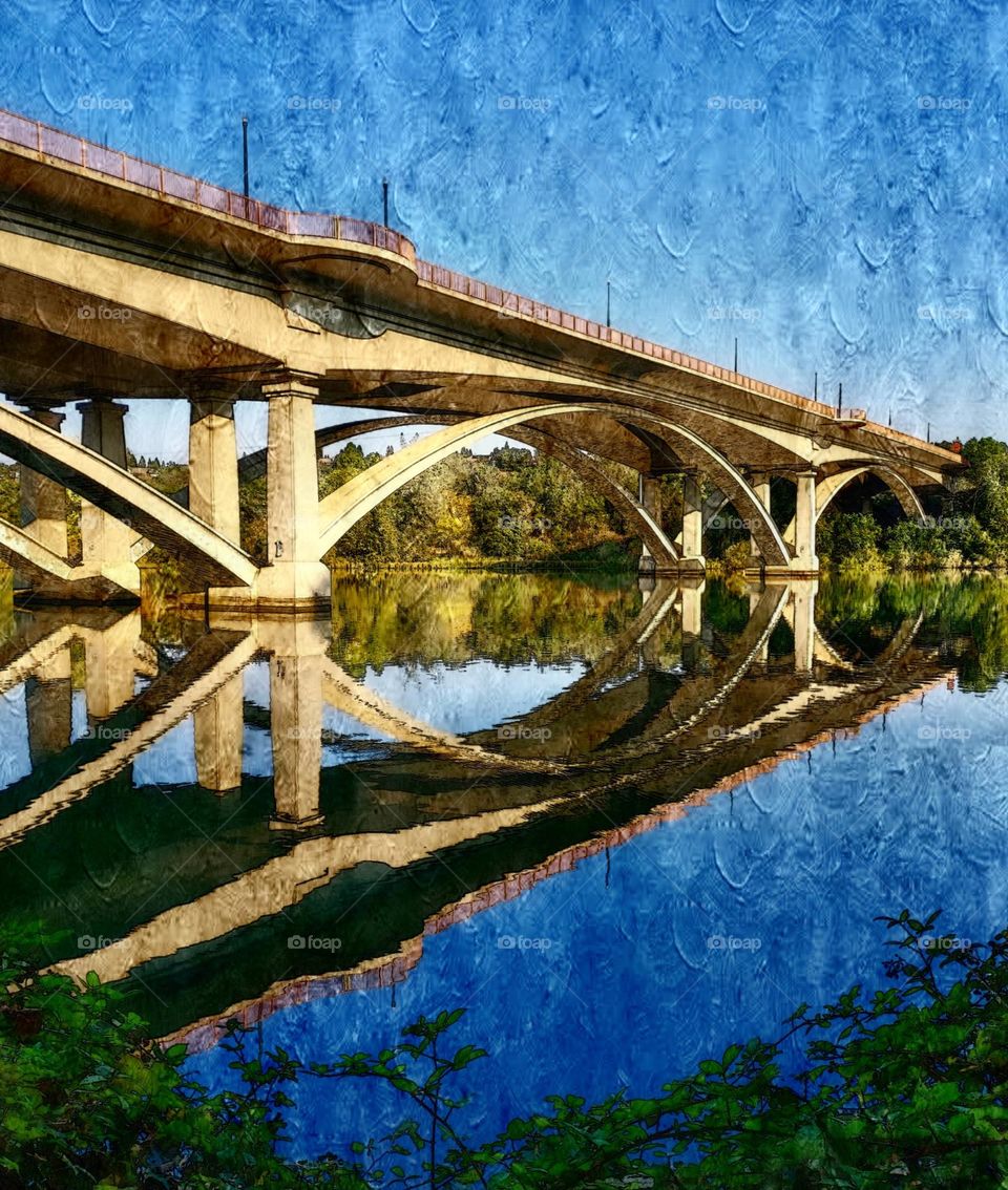 A digital oil painting of a mirrored reflection of a bridge off the water