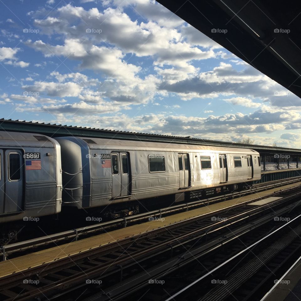 City Sky clouds train sun.. Historic NYC A train costing through Ozone park, Queens on a plethora of clouds sunny day!  