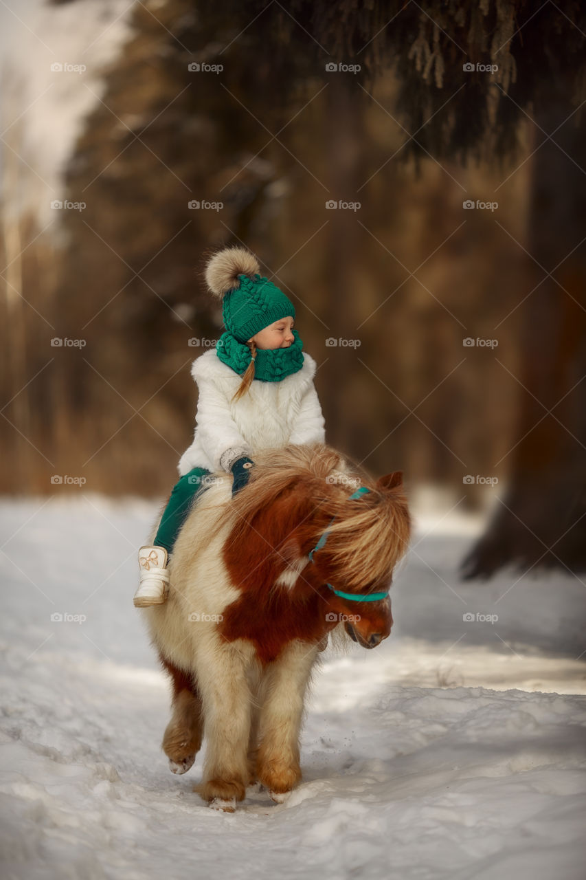 Little girl with pony at early spring day