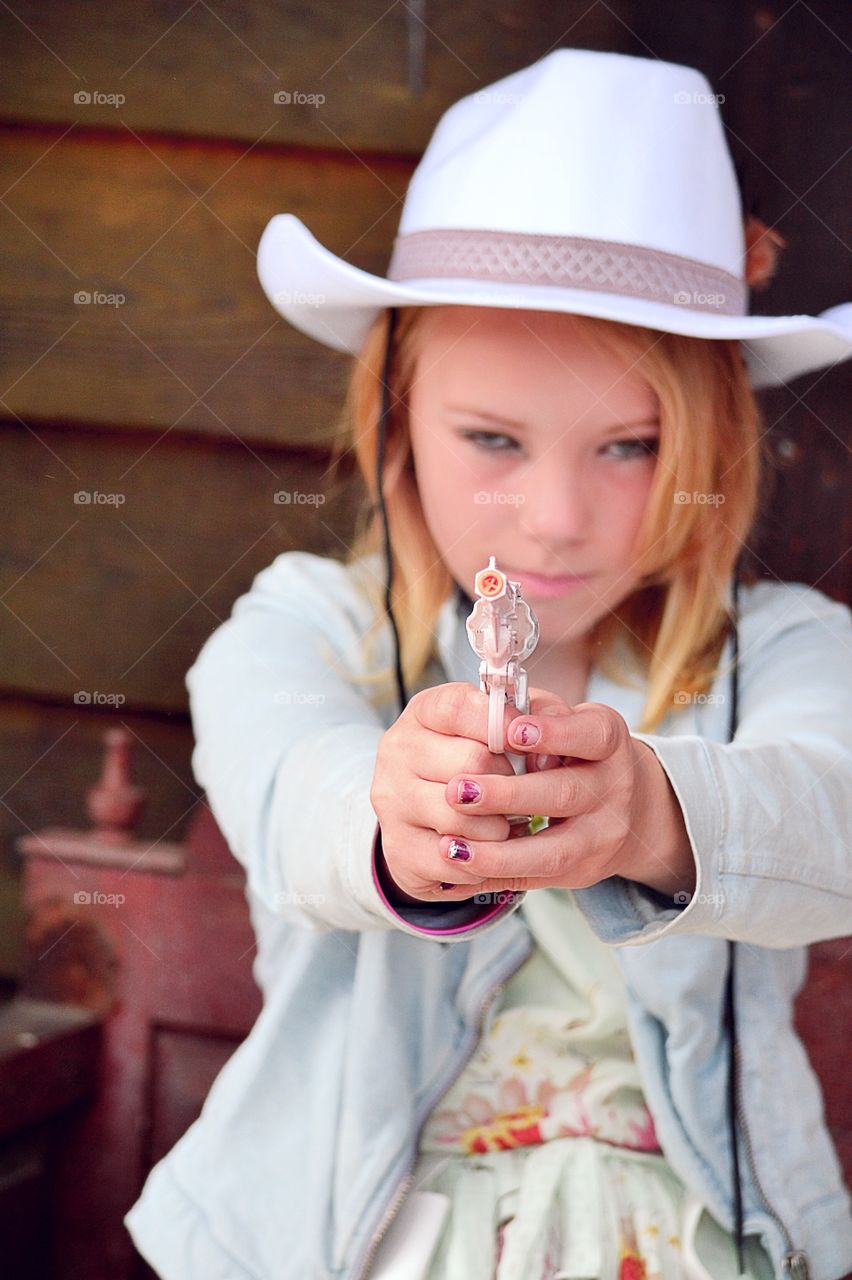 Hands up. Girl playing with her toy gun