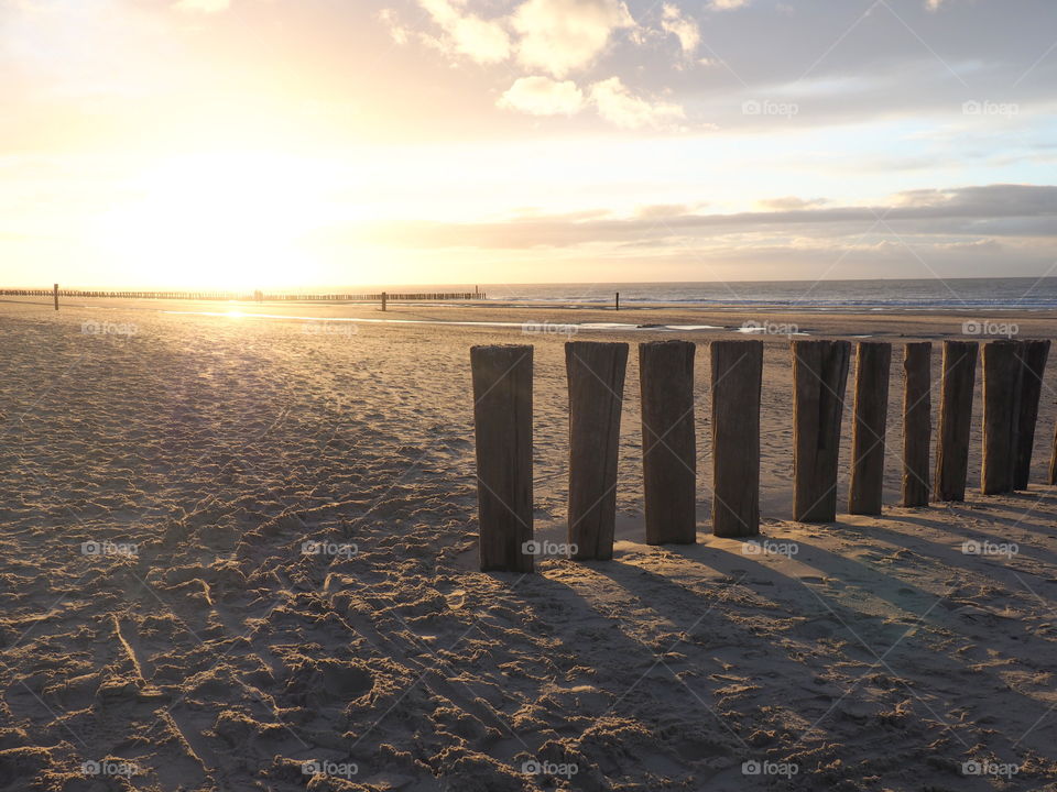 Golden sunset at the beach in Zealand, the Netherlands with view on the ocean and the seaside.