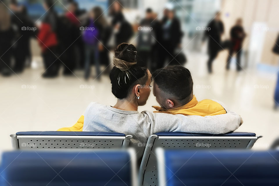 Young man and woman in love together waiting for a plane at the airport before departure 