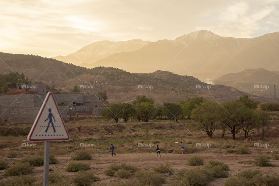Boys playing football in the mountain valley
