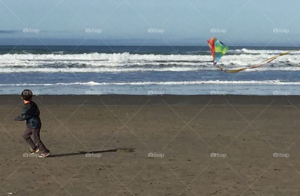 Child flying a kite at the beach