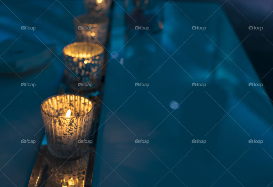 Sparking candlelight on holiday party for Christmas or New Year’s eve Background with blue Ambience light 