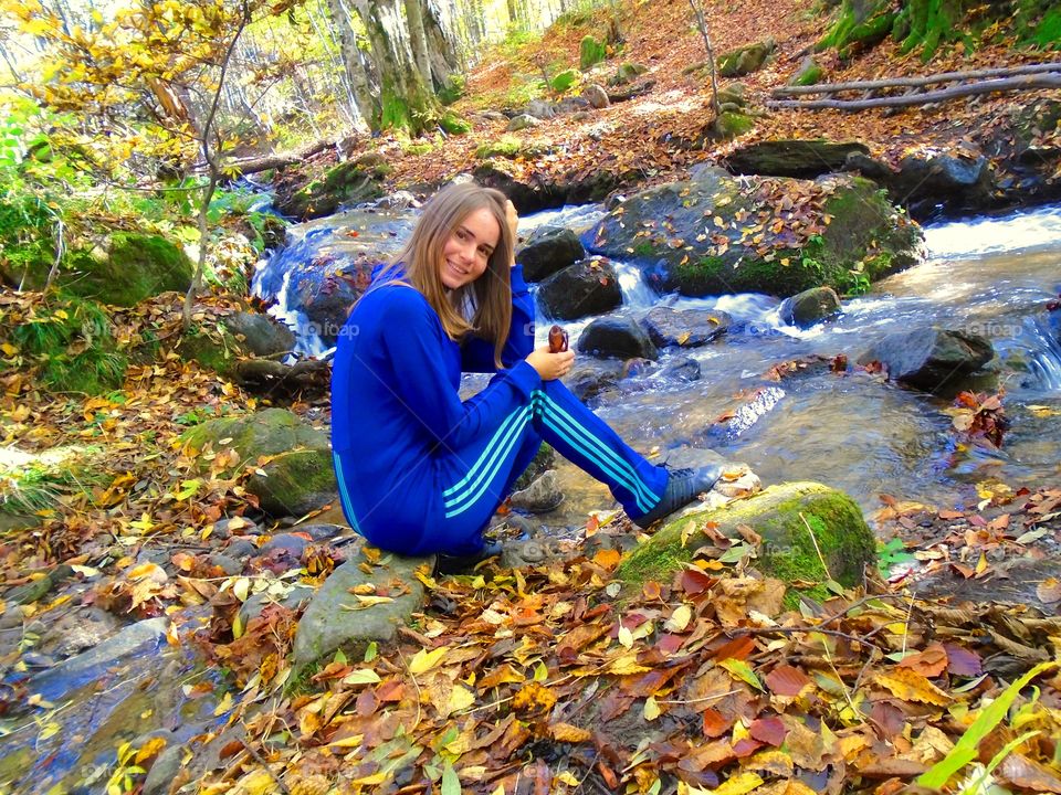 Happy girl sitting near river side