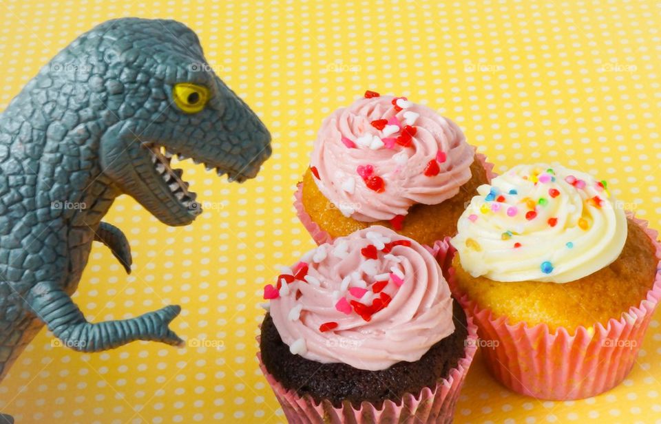 Dinosaur toy and cupcakes
