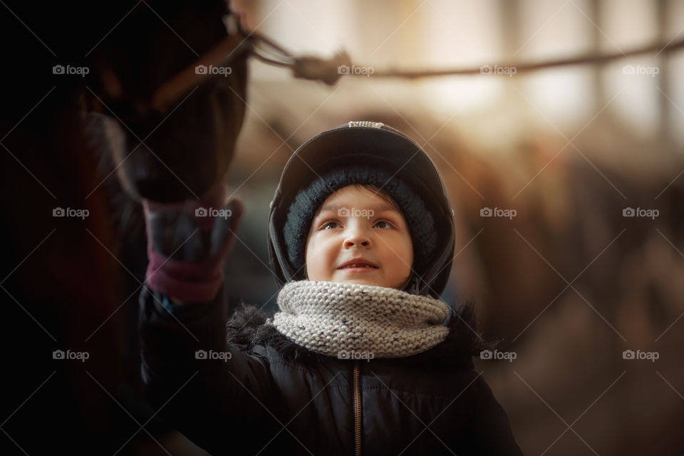 Girl in horse riding wear in a stable