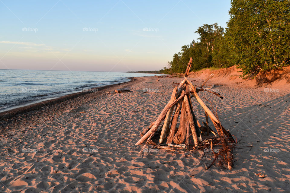 Wood for a bonfire on a beach at sunset