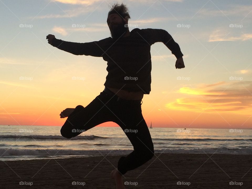 Fun silhouette on the beach at sunset