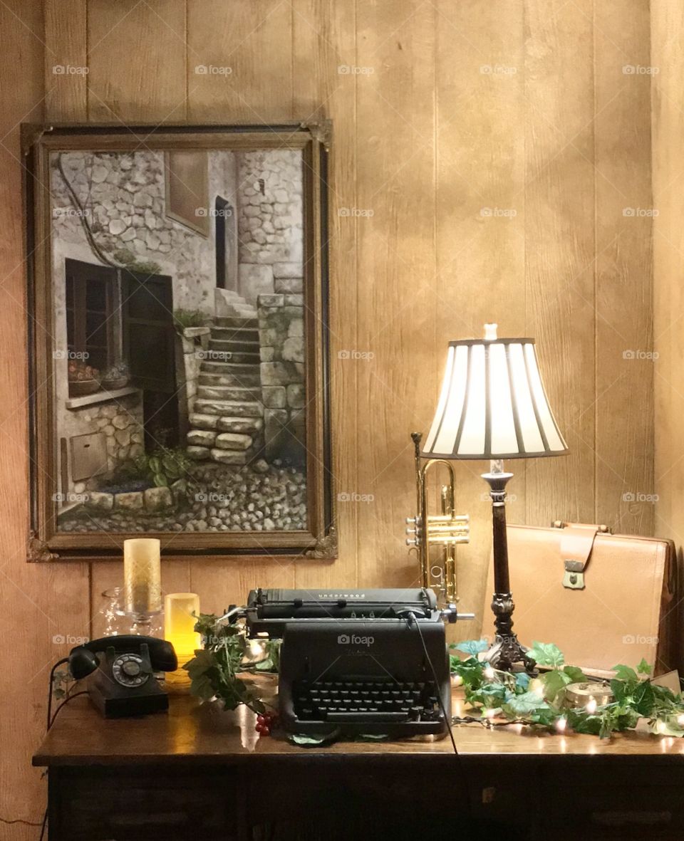 Still life with old typewriter, old phone, lamp, trumpet, briefcase 