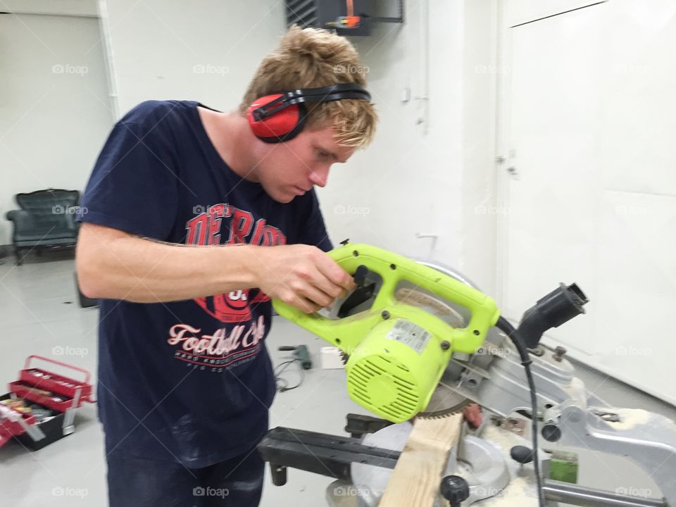 Man working with a cross-cut saw in a construction site.