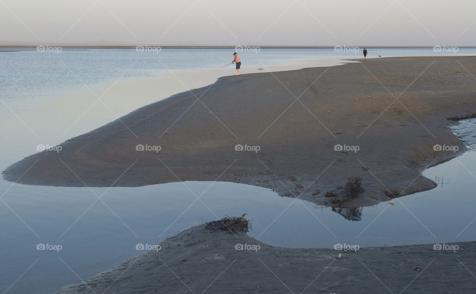 A lone fisherman tries his luck from the beach on the Sea of Cortez,