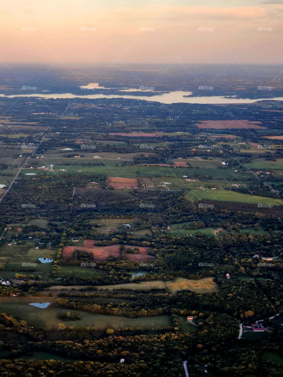The sun sets over the flat plains of the American Midwest which resembles a patchwork quilt