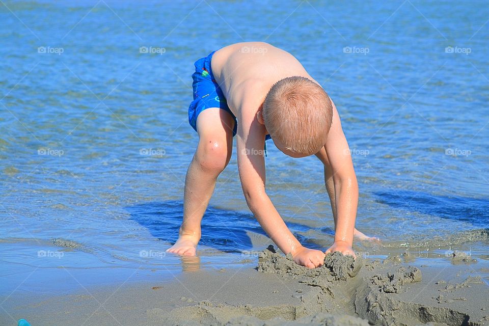 Boy digging in the sand