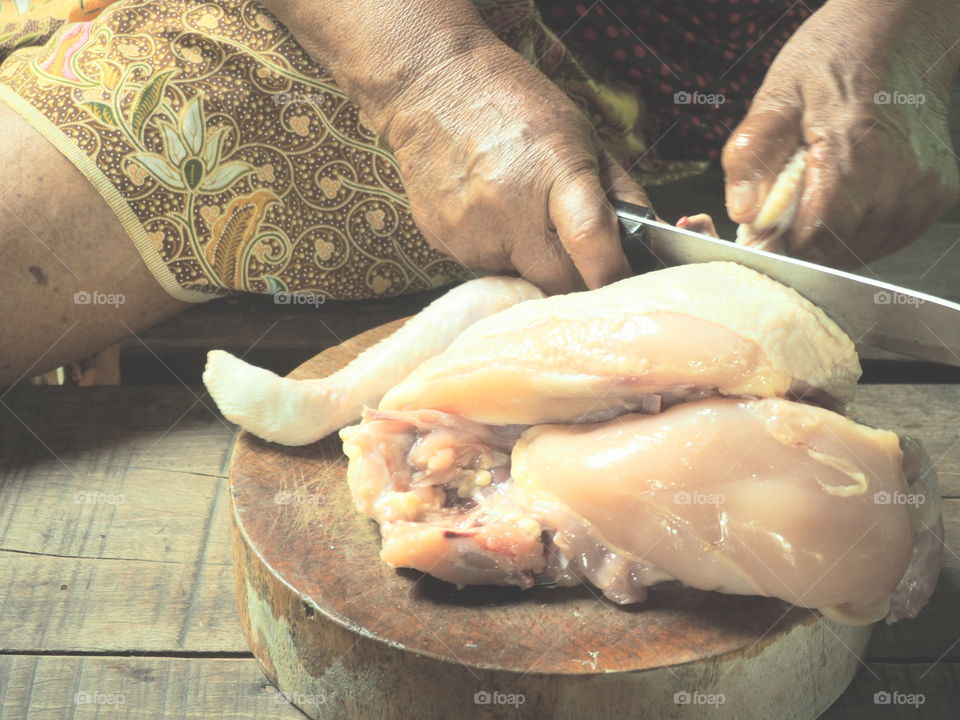 Cooking in kitchen,Person cutting poultry on wood board in kitchen of asia people
