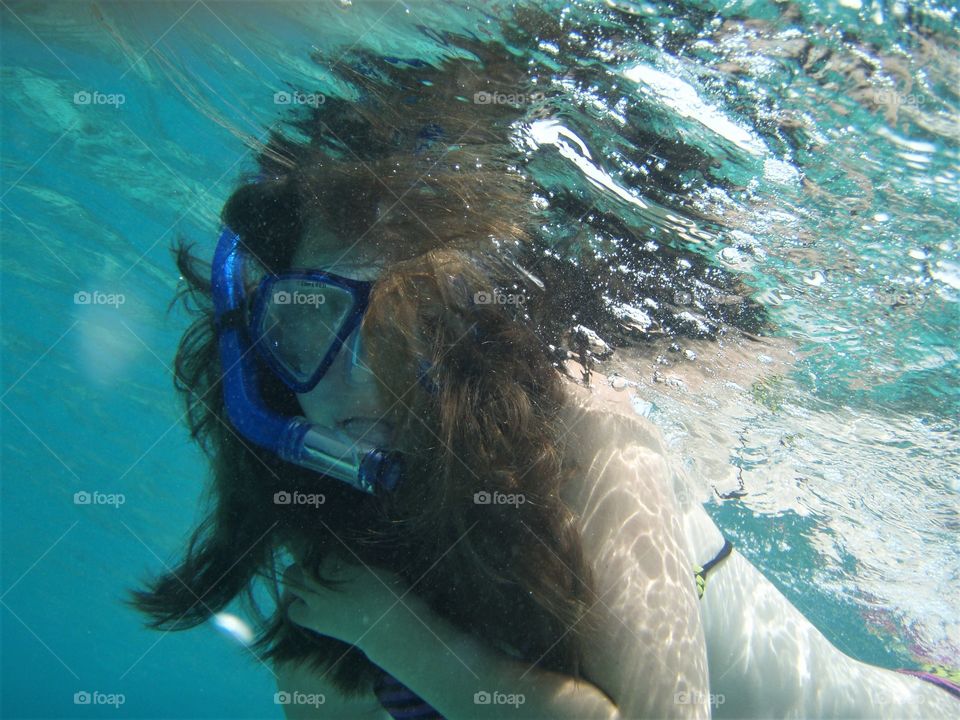 Camera shy snorkeling girl not happy with underwater paparazzi