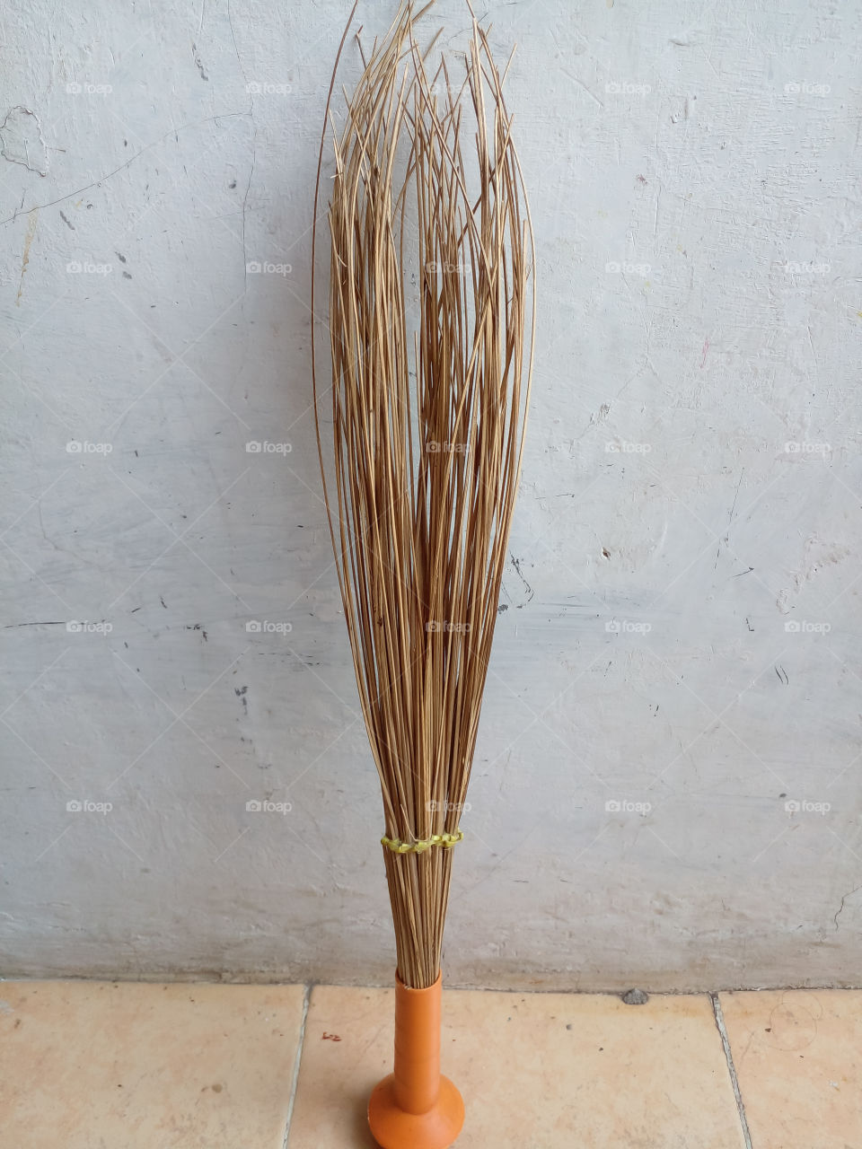 a broomstick leaning against white wall