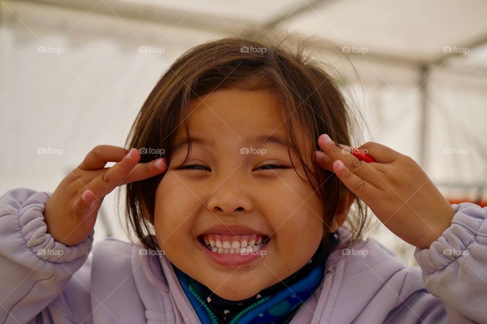 Close-up of a cute little girl with funny expression