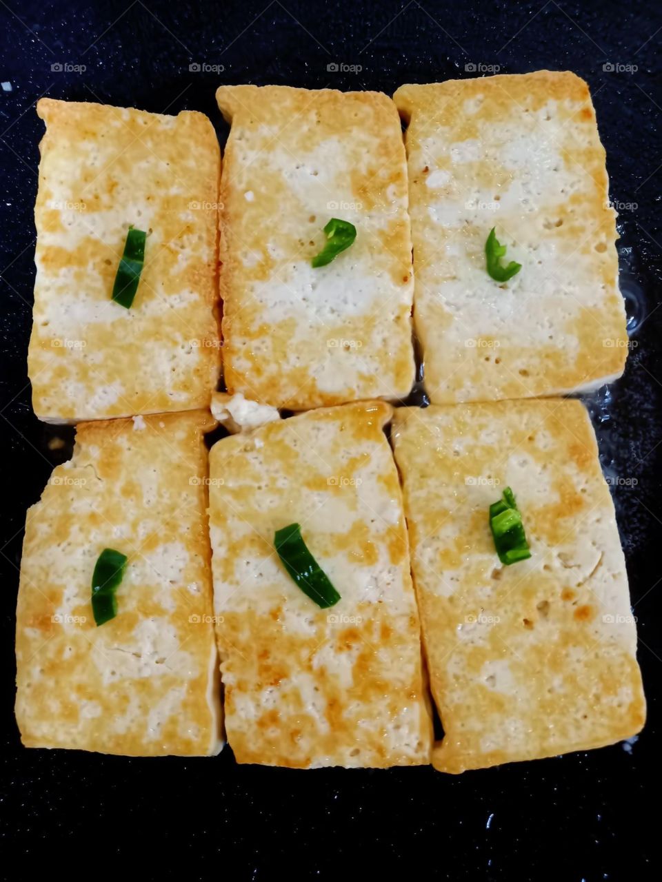 cooking fried tufo with little salt and green spicy on the top.
