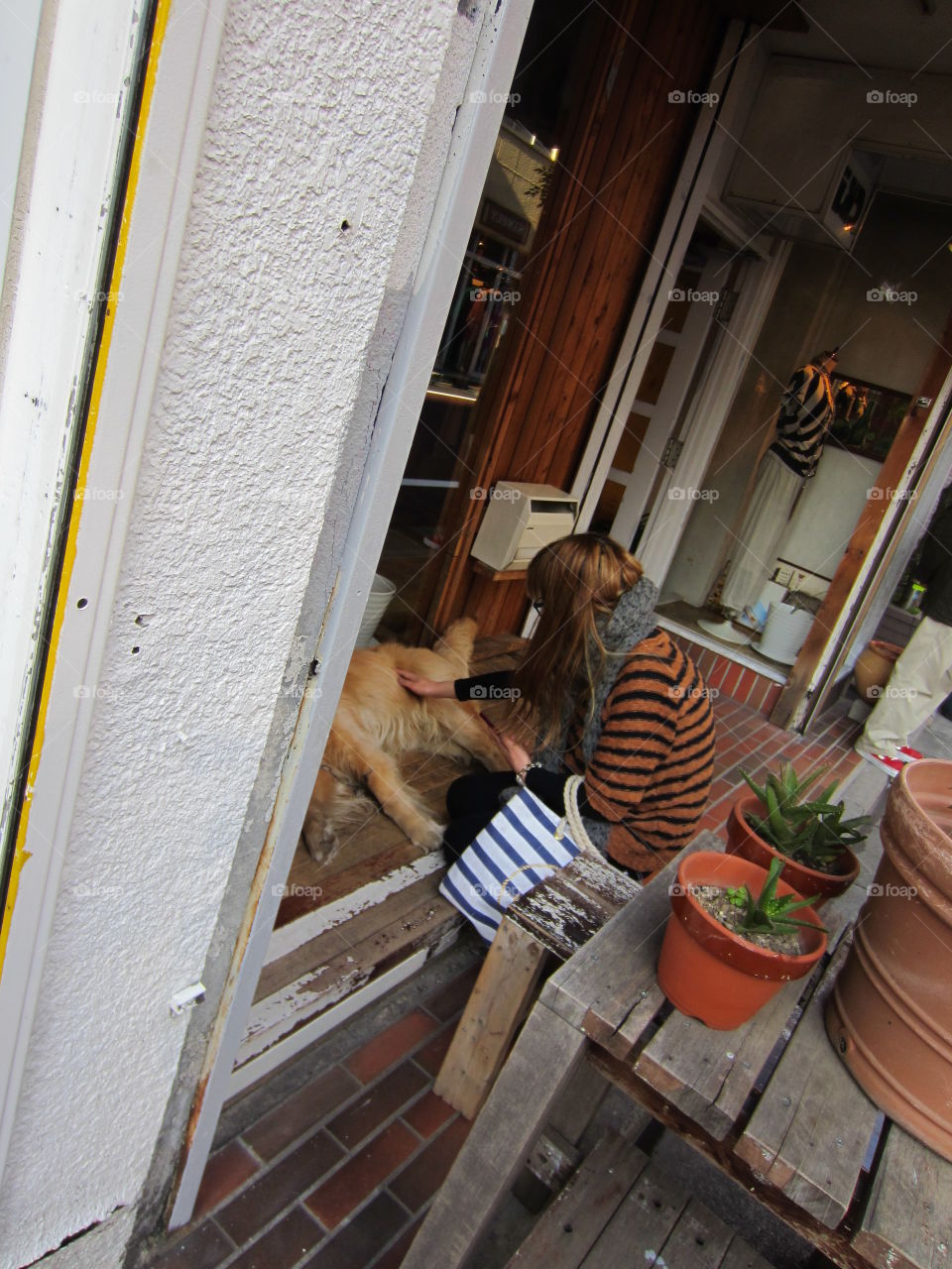 Nakameguro, Tokyo, Japan. Woman Petting Dog Outside Shop.  Springtime.