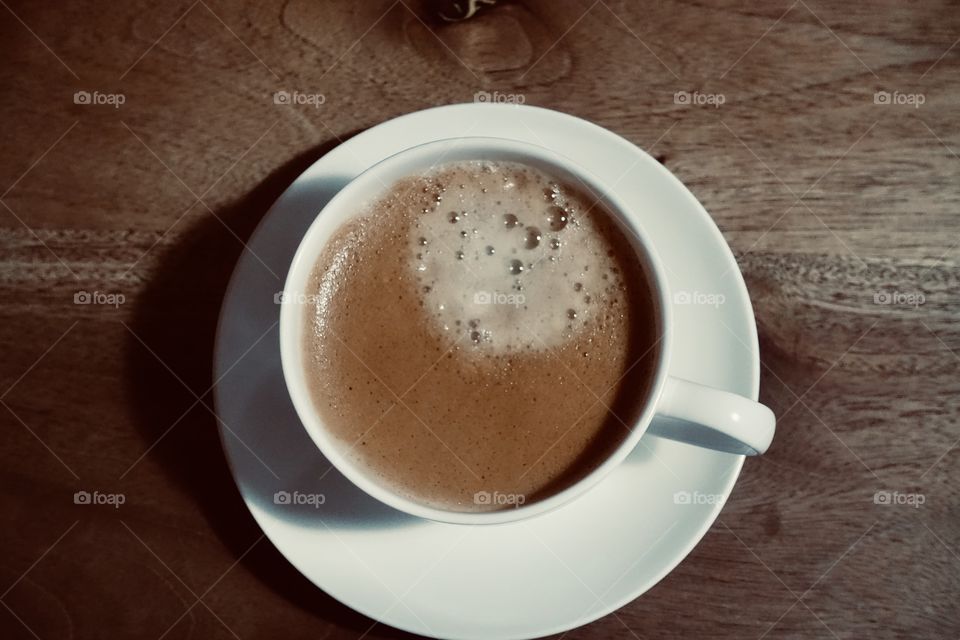 A cup of espresso on the wooden table.