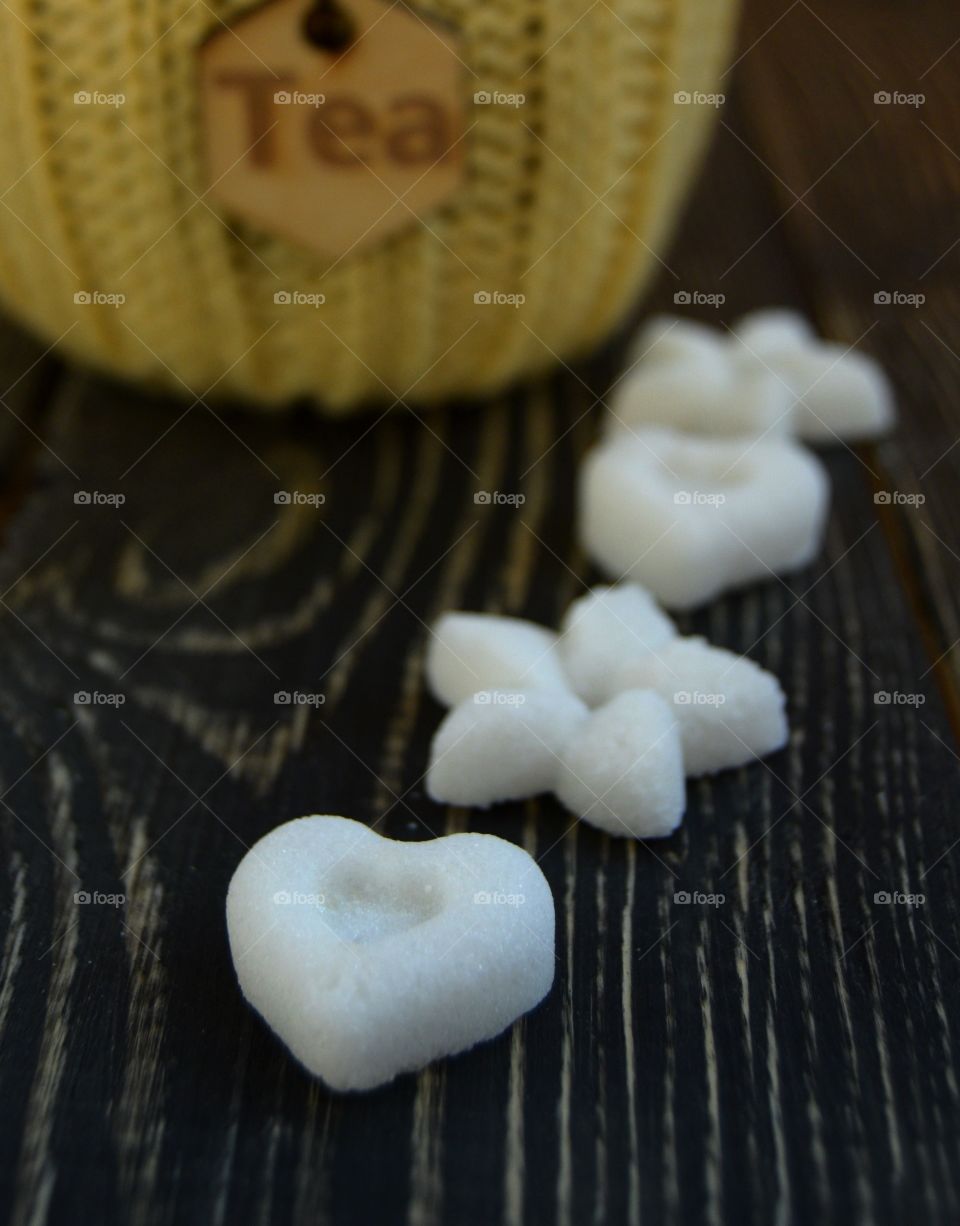 Sugar in form of heart and flower on wooden background 