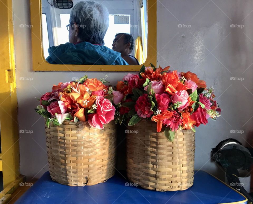 two straw vases with different flowers on a passenger boat to Angra dos Reis