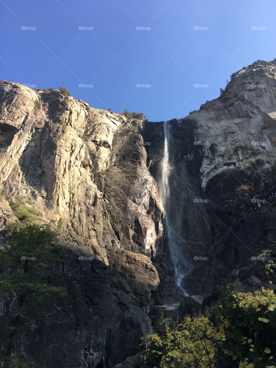 A view of Bridal Veil Falls on a clear blue sky day where there are no clouds persons or obstructions of the view from the bottom of the falls. 