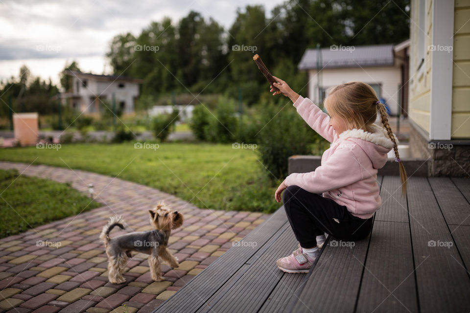 Kid playing with dog on backyard 
