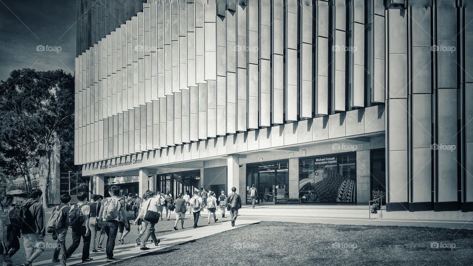 People walking towards the Hilmer Building of The University of New South Wales, Sydney, Australia. The Michael Crouch Innovation Centre is on the ground floor. Monochrome version.