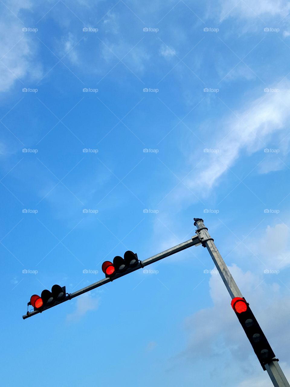 A look up Minimalist photo of Street red light with blue sky and clouds.