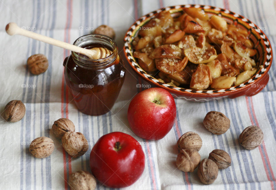 Cooking at home, cozy autumn days, baked apples, honey and walnuts on the table