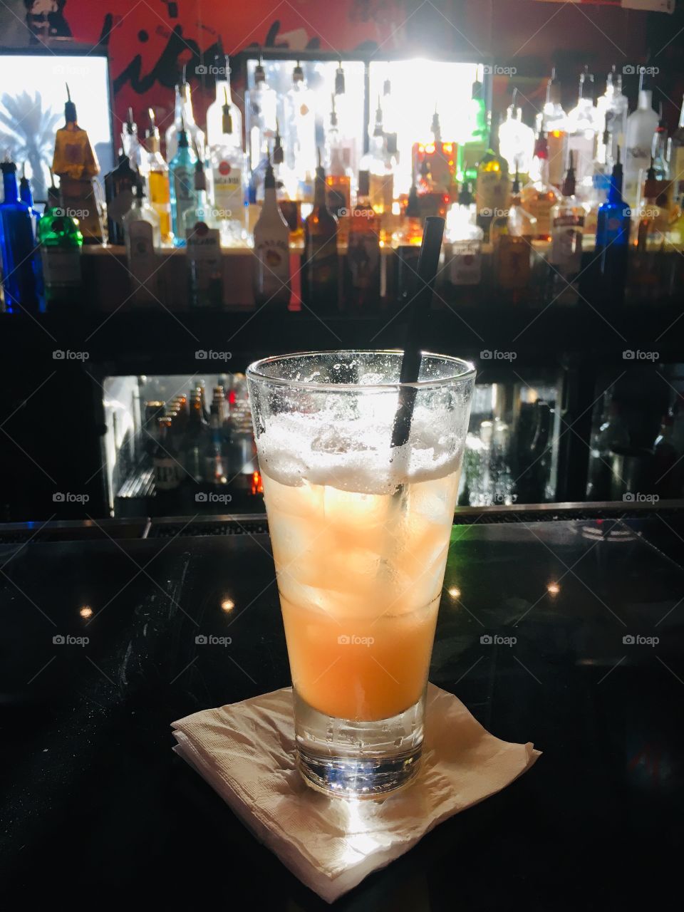 Sunshine shining through liquor bottles at the bar in my drink