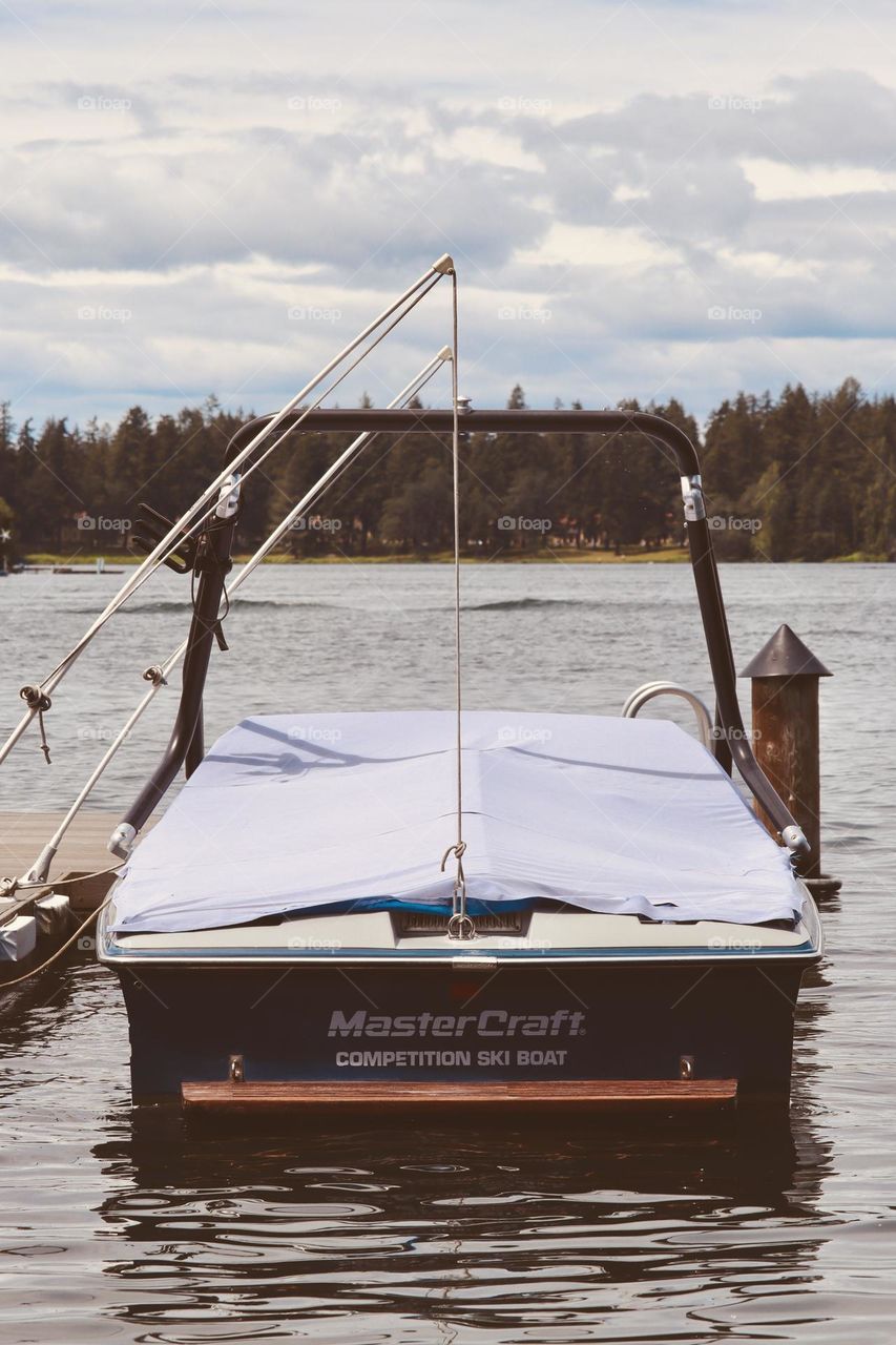 A competition ski boat is docked on a sunny evening at American Lake, Tillicum, Washington 