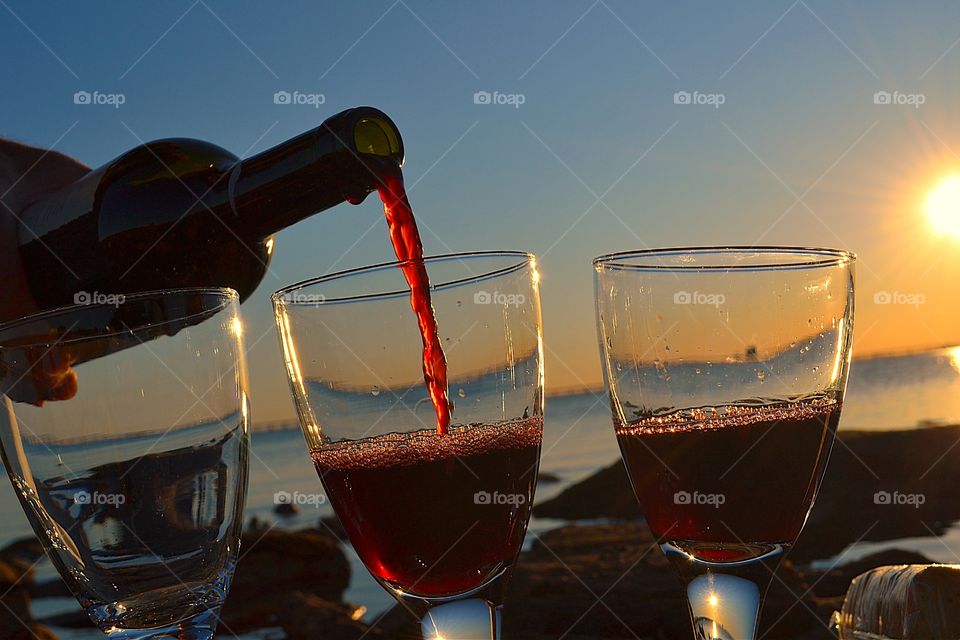 Wine Glow. Pouring red wine (Shiraz) at sunset on ocean in South Australia 